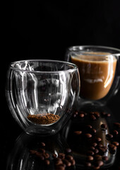 Coffee in a glass, on a black background, from coffee beans. Morning