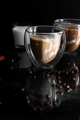 Coffee in a glass, on a black background, from coffee beans. Morning