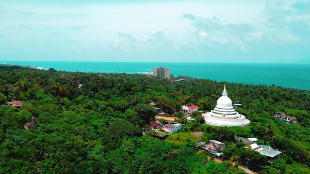 Aerial view temple on mountain amidst jungle by beach. Great for travel, nature, and cultural content. Explore this serene vista.