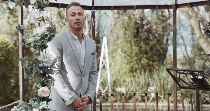 Waiting, groom and man in wedding and ceremony at alter with anxiety, stress or nervous energy for marriage or commitment. Formal, suit and excited person standing in aisle with flowers and nature