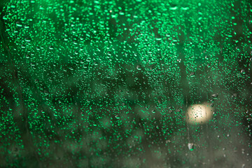 Carwash water on windshield with green light