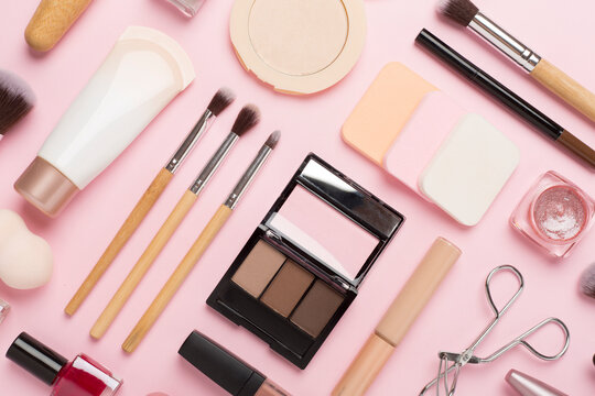 Flat lay with makeup products and tools on color background