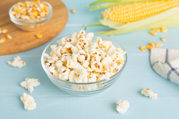Prepared popcorn with ingredients on wooden table