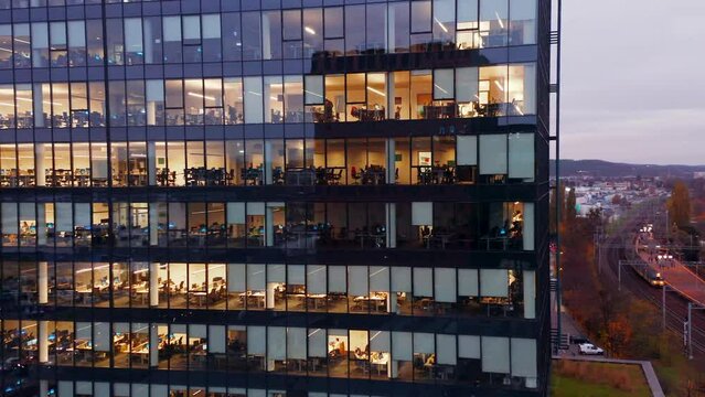Cinematic shot of corporate office buildings skyscrapers illuminated at night.