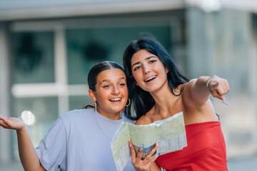 two travel girls on the street with a map