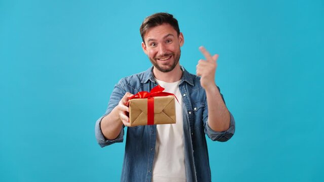 Man stands up and gives gift in box with red ribbon