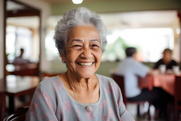 Smiling portrait of a happy senior latin or mexican woman in a nursing home - obrazy, fototapety, plakaty