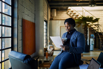 Young African American businessman going through paperwork while working in a startup company office