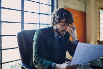 Young Caucasian male designer stressed with how his work turned out in a startup company office