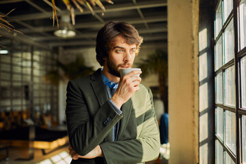 Young man enjoying a cup of coffee on a break in a startup company office