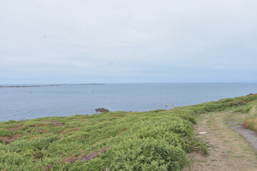 Fototapeta na wymiar View to pier and coast, dramatic sky, isles of Scilly, United Kingdom