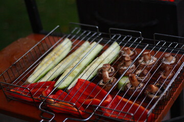 cook vegetables on an open fire on a grill, mushrooms, paprika, zucchini, onions