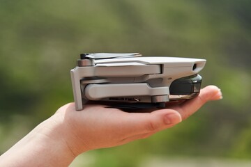Modern small compact quadcopter in a girl's hand. Launching a drone from your hand. High quality photo
