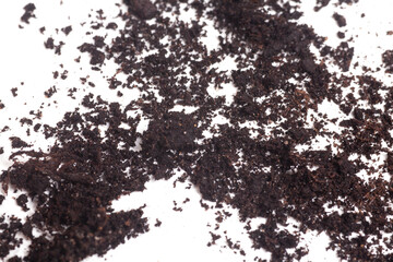 Grain of black earth on white background. Natural soil texture.