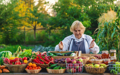 old woman farmer sells vegetables and fruits at the farmers market. Selective focus.