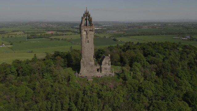 Aerial flying around Wallace Monument national scottish heritage landmark on Abeey Craig hilltop near Stirling city in Scotland, UK