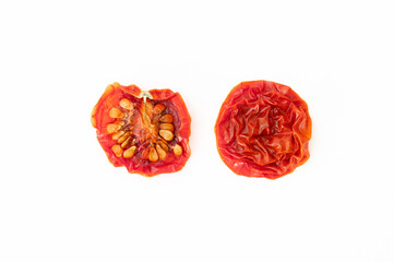 A dried cherry tomato sliced in half on white background