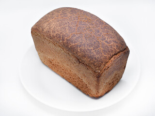 A black loaf of bread on a white background. Freshly baked bread.