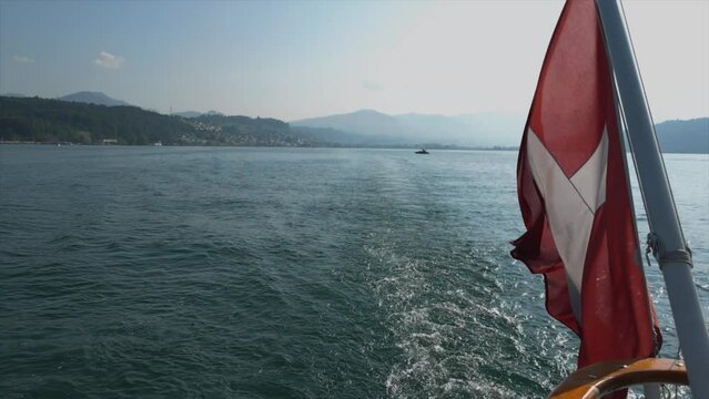 A Swiss flag at the stern of a passengers boat on the lake of Lucerne, Switzerland.