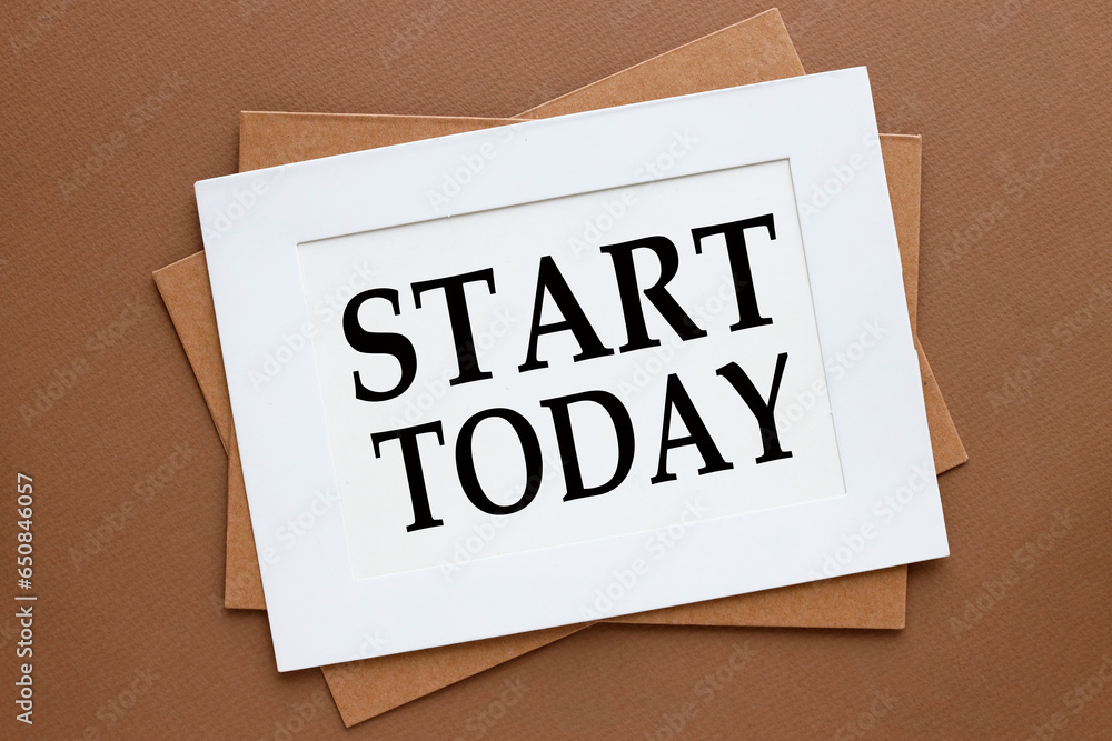 Poster START TODAY - top view of a white page in a paper frame.brown background. words