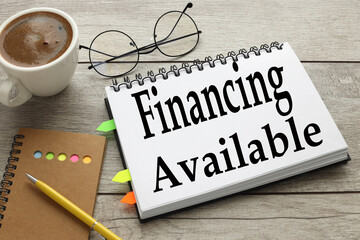 Financing Available. open notebook with text near coffee cup