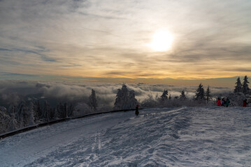 Clouds and sky with sun above from Lysa hora hill in winter Moravskoslezske Beskydy mountains in...