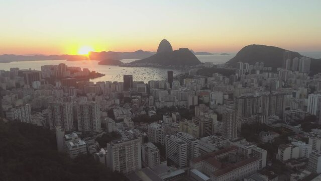 Sunrise aerial approach of Rio de Janeiro Sugarloaf Mountain Copacabana with Guanabara Bay in the background high rise apartment blocks in the foreground