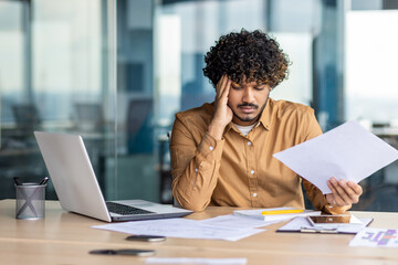 Upset financier looking at sales and revenue chart of company, businessman inside office...