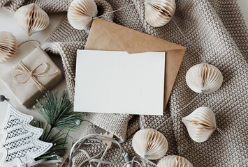 Cards mockup, envelopes, christmas garland and beige knitting plaid top view background. copy...