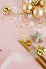 Christmas table setting with Xmas golden decor top view on pink background with copy space .