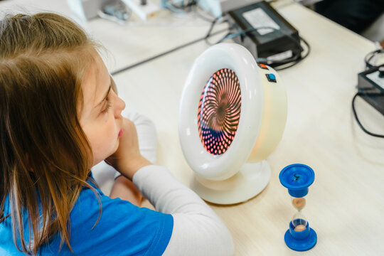 Little girl in medical office undergoing advanced laser vision treatment, correction for eyes health. Pediatric ophthalmology procedure. Visual acuity, strabismus improvement. Advanced technology