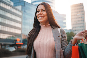 Close up photo of happy smiling woman in her early thirties walking down the city street and...