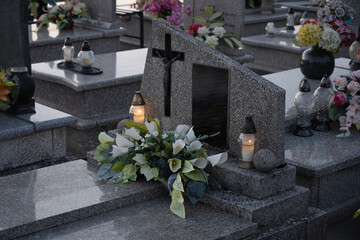 Catholic grave decorated with white flowers and candles. - obrazy, fototapety, plakaty