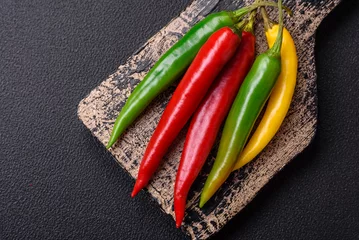 Foto op Canvas Hot chili peppers of three different colors red, green and yellow © chernikovatv