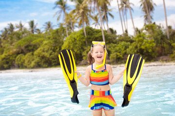 Child with swim fins snorkeling on tropical beach. - obrazy, fototapety, plakaty