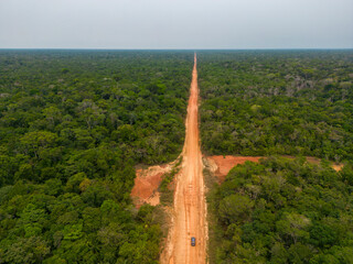 Drone shot of the famous BR-319 in dry season, a dirt road through the Amazon rainforest between...