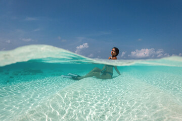 Fototapeta na wymiar beautiful young woman enjoys snorkeling in the indian ocean. active holiday in the Maldives.