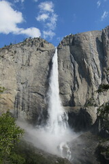 Vertical shot of a beautiful waterfall flowing through the mountains in Yosemite National Park, USA
