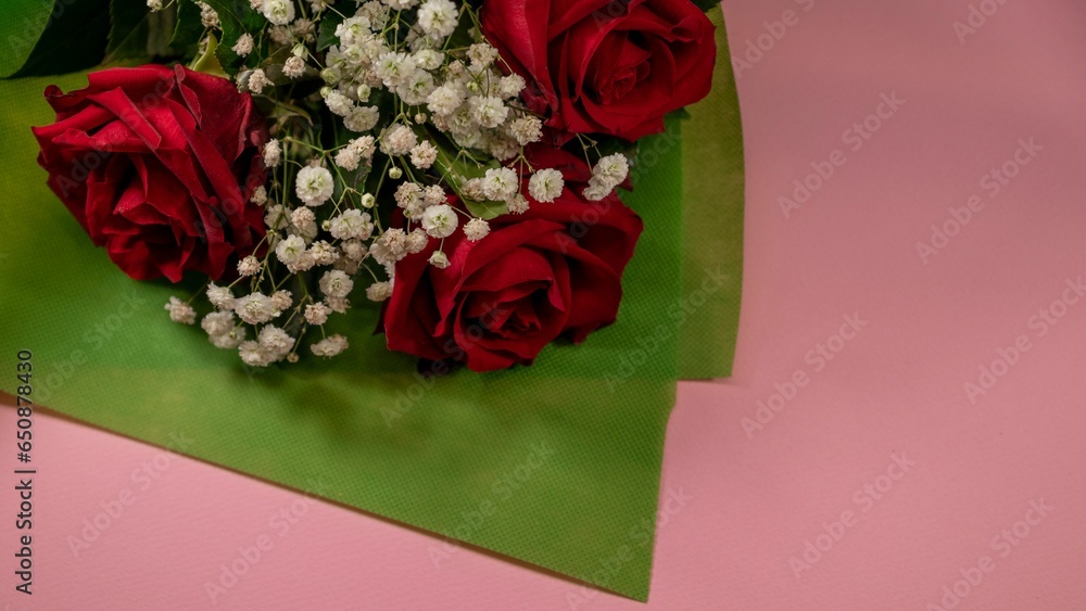 Poster Closeup of a bouquet of beautiful red roses on a pink surface