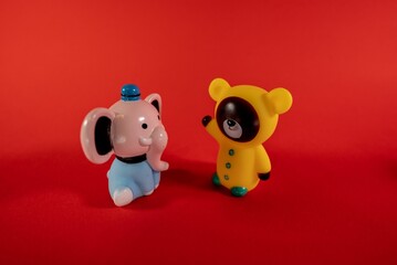 Closeup of animal toy figurines on a red background with copy space