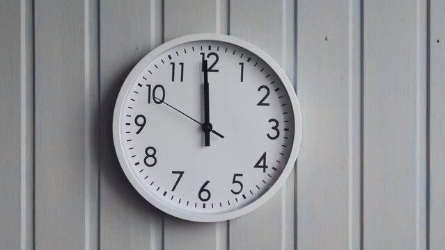 the clock on the wall shows noon or midnight, the second hand is approaching 12 o'clock.