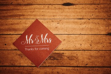 Wooden table with a napkin with a quote 'Mr and Mrs, thanks for coming'