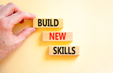 Build new skills symbol. Concept word Build new skills on beautiful wooden block. Businessman hand. Beautiful white table white background. Business, education build new skills concept. Copy space.