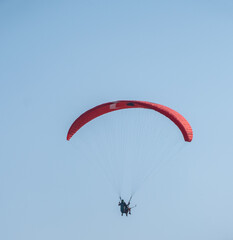 paragliding in the air from far blue sky