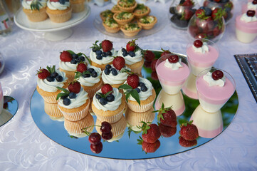 Delicious sweets of cupcakes with blueberry and strawberry on a welcome buffet table