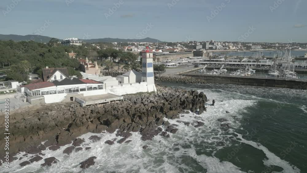 Sticker Drone over lighthouse and stone barrier on the sea near harbor under blue sky