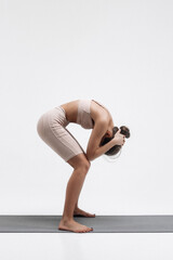 Young attractive girl practicing yoga isolated on white background. Concept of healthy life and...