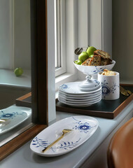 Set of white ceramic dishes on the windowsill