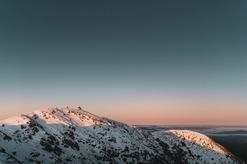 a snow covered mountain with a sunset behind it is shown