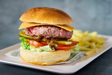 a hamburger with a side of pickles and a fries
